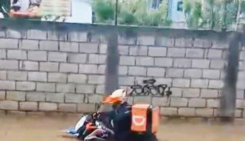 Repartidor de comida queda atrapado en la calle inundada, vecinos acuden al rescate