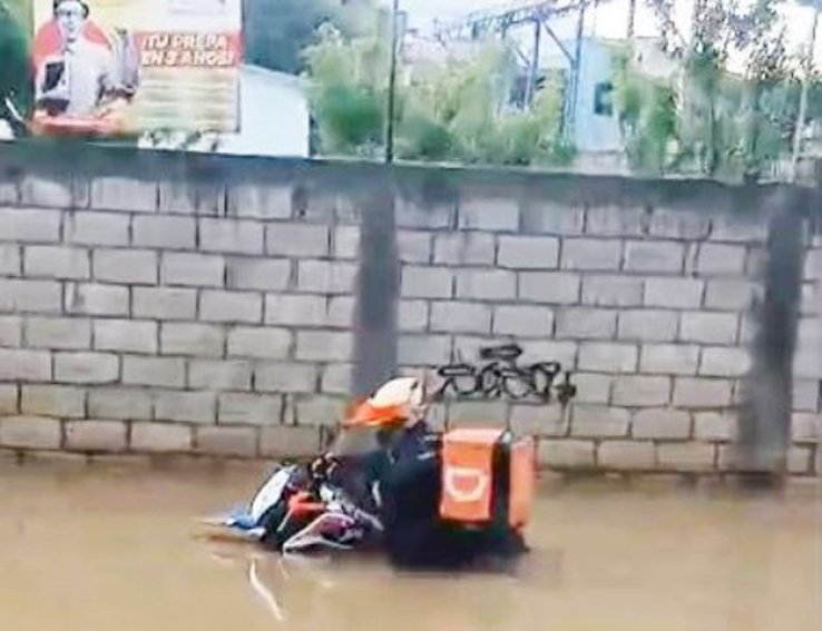 Repartidor de comida queda atrapado en la calle inundada, vecinos acuden al rescate